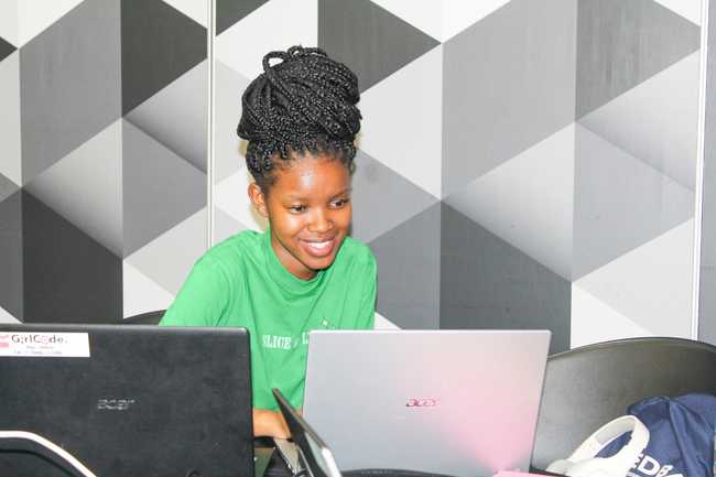 A young woman coding at the AI Mashup 